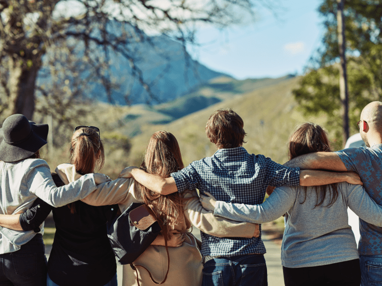 teenagers standing on top of a mountain